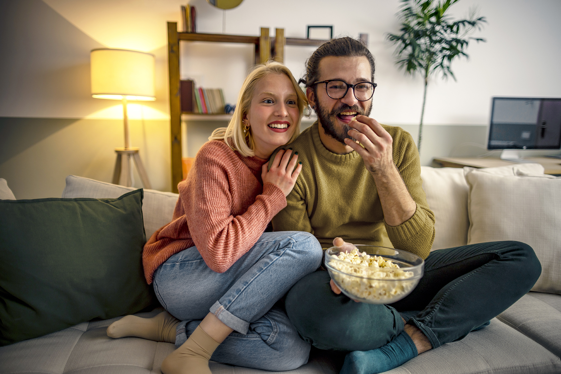 Couple watching TV and eating popcorn